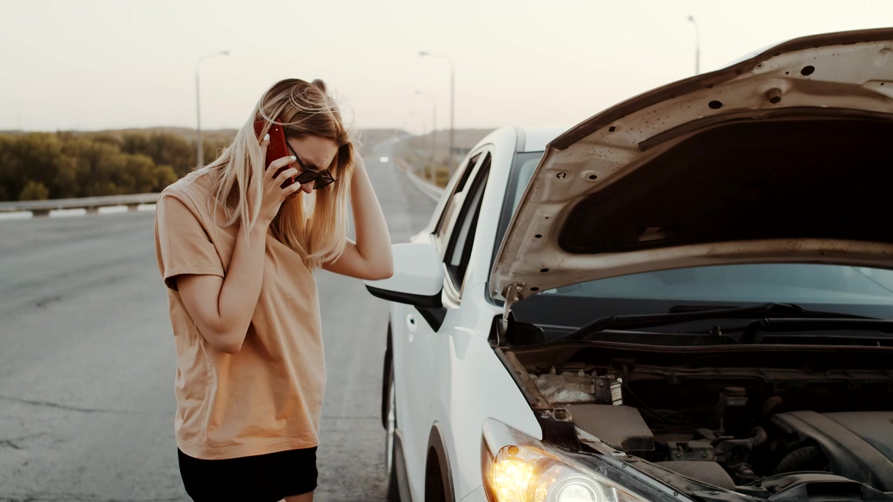 Driver calling for help beside a damaged car after an accident near Tampa